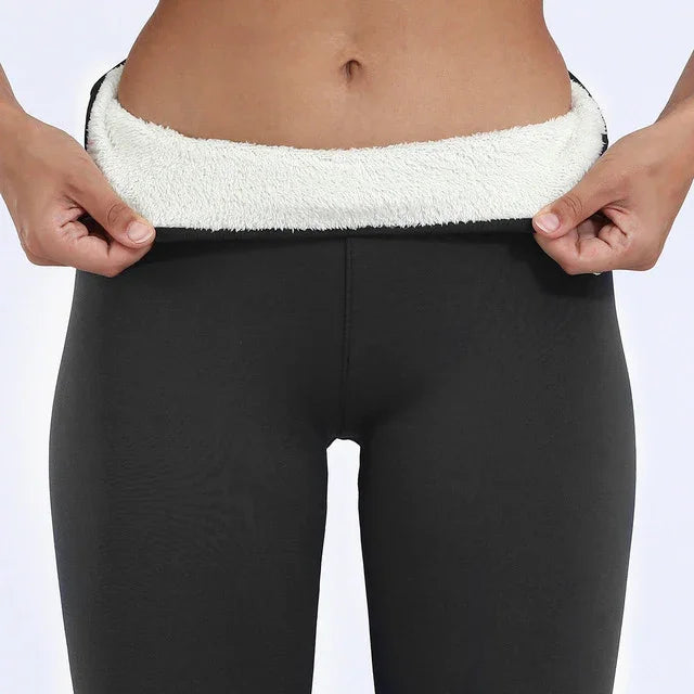 Close-up of person showing inner white fleece lining of black thermal leggings for warmth