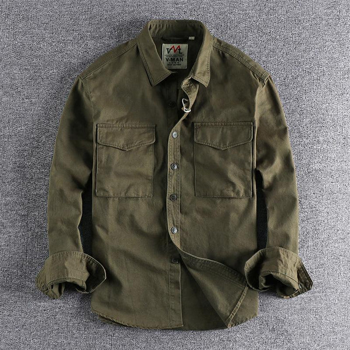 Men's olive green button-up shirt with two chest pockets and rolled-up sleeves on gray background