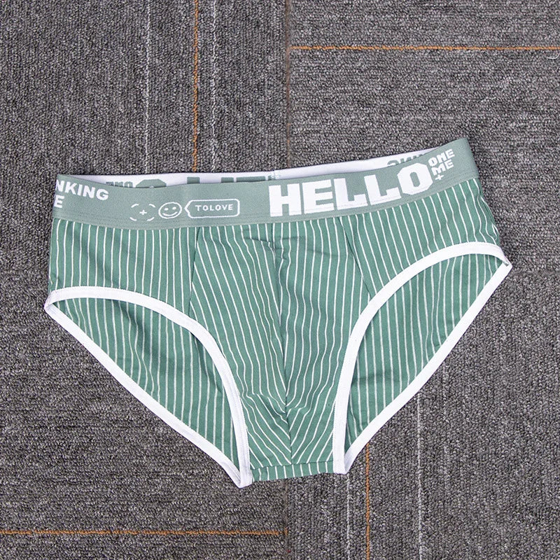 Green and white striped men's briefs with gray waistband featuring HELLO text and smiley icon on carpet
