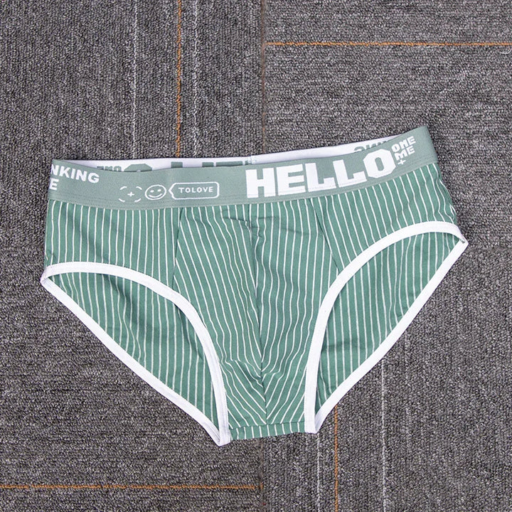 Green and white striped men's briefs with gray waistband featuring HELLO text and smiley icon on carpet