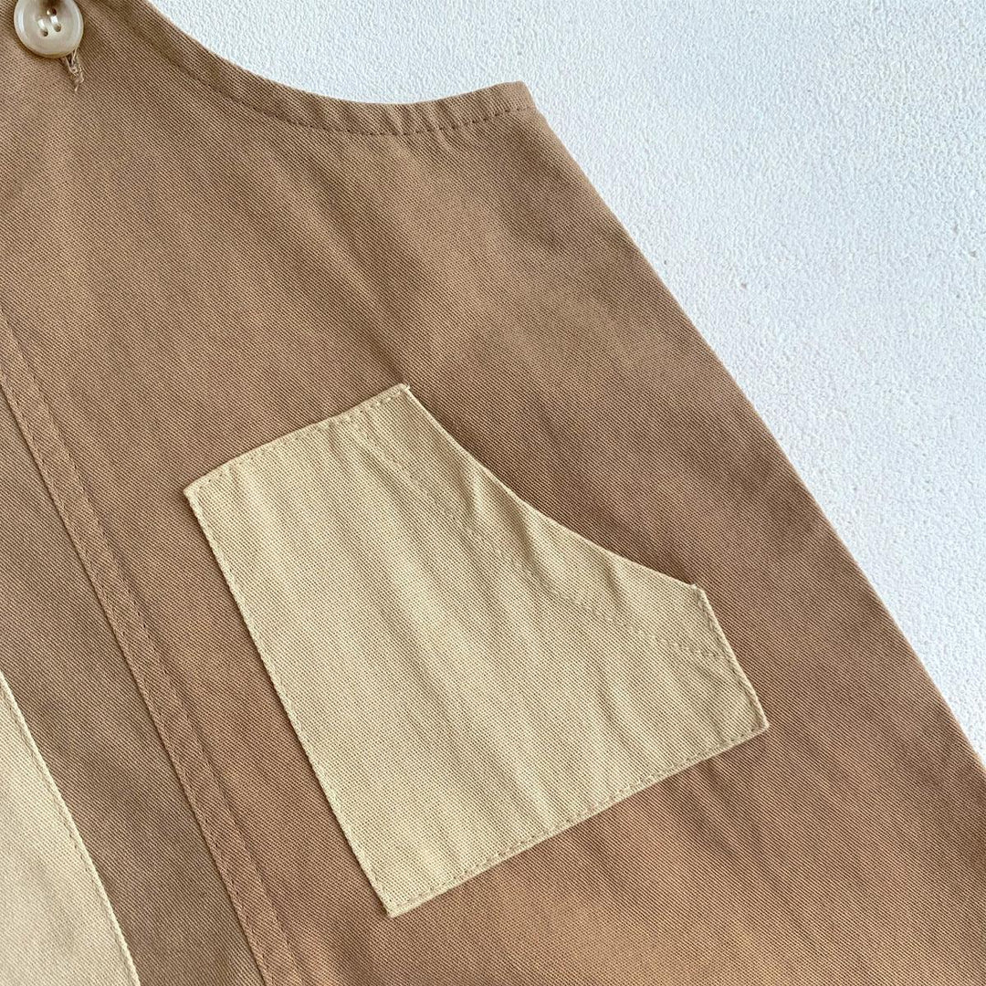 Close-up of beige and brown cotton fabric with a contrasting small pocket and button detail