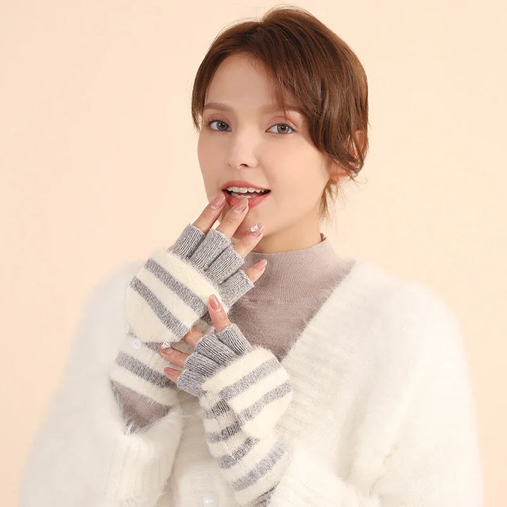 Woman wearing striped fingerless gloves and a white fuzzy sweater against a beige background