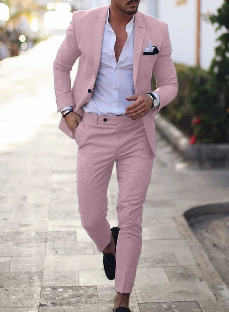 Man wearing a slim fit light pink suit with white dress shirt and black loafers walking outdoors