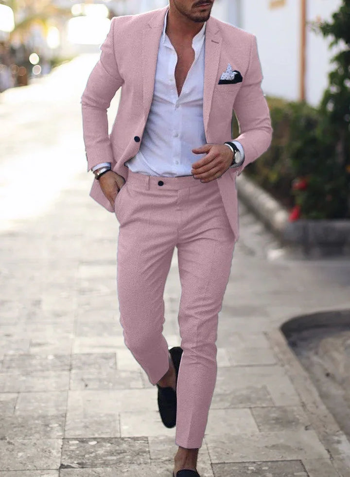 Man wearing a slim fit light pink suit with white dress shirt and black loafers walking outdoors