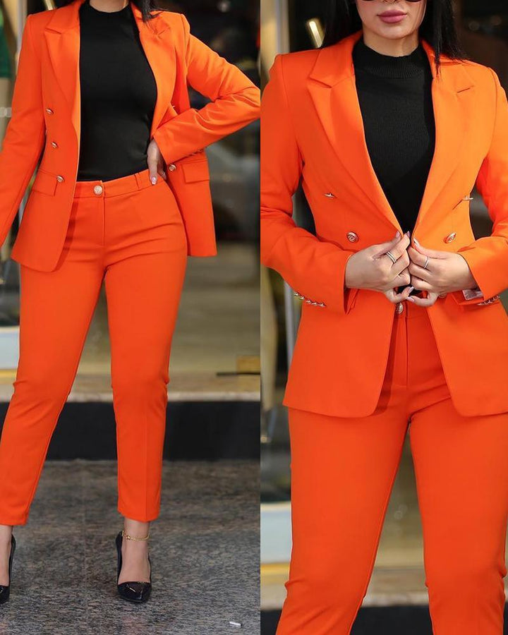 Woman wearing a bright orange suit with tailored blazer and pants, paired with black top and black heels