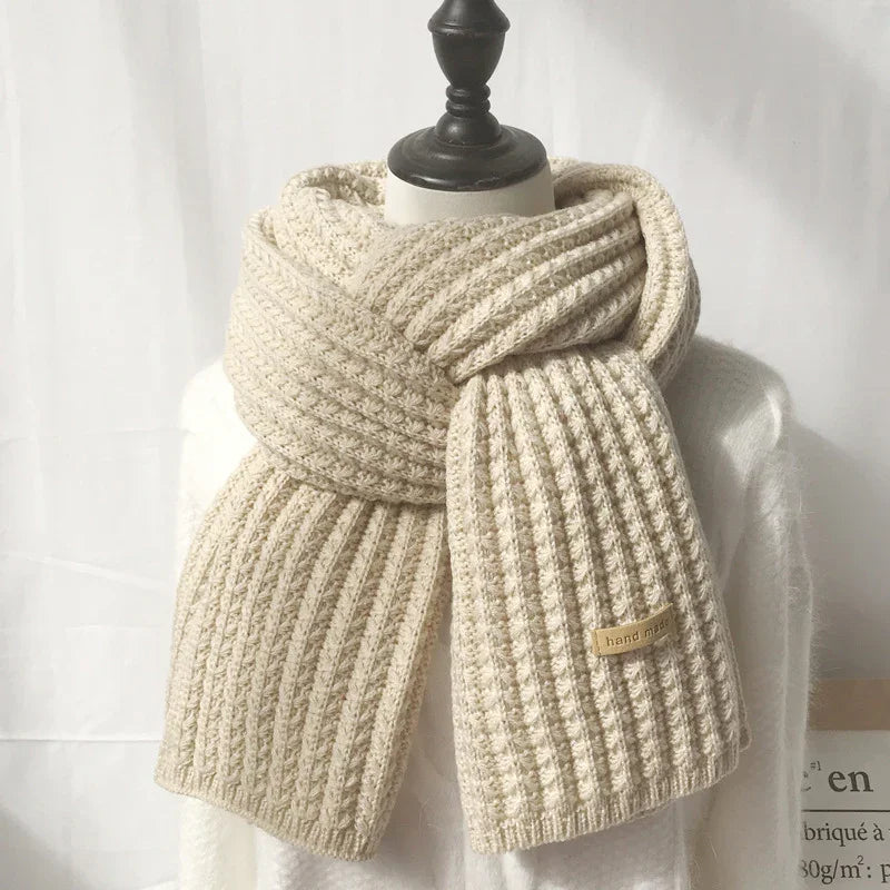 cream-colored handmade knitted scarf with ribbed pattern on mannequin