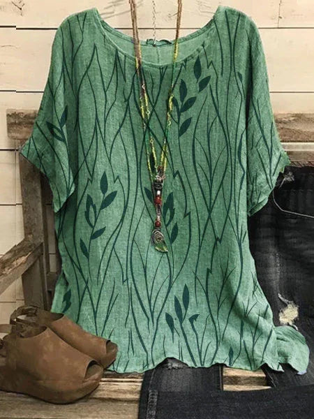 Green short-sleeve top with leaf pattern paired with ripped jeans and brown peep-toe shoes