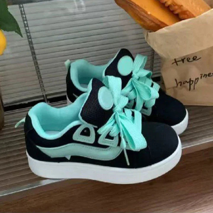 black and mint green casual sneakers with thick white soles and large mint green laces on a wooden surface