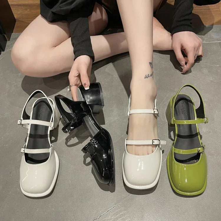 Woman sitting on floor with patent leather Mary Jane shoes in white, black, and green colors