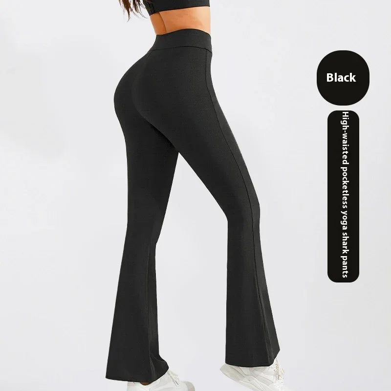 Black high-waisted pocketless yoga shark pants worn with white sneakers on model side view