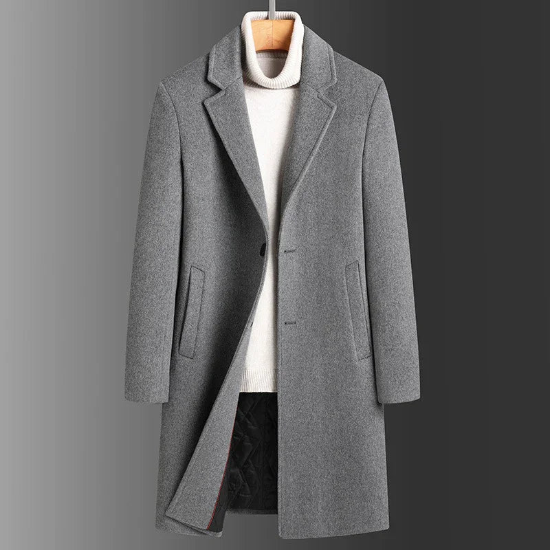 Gray wool men's overcoat with lapel collar and side pockets over white turtleneck sweater