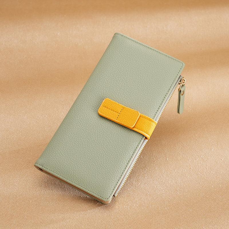 Light green leather wallet with yellow strap and zipper on beige background