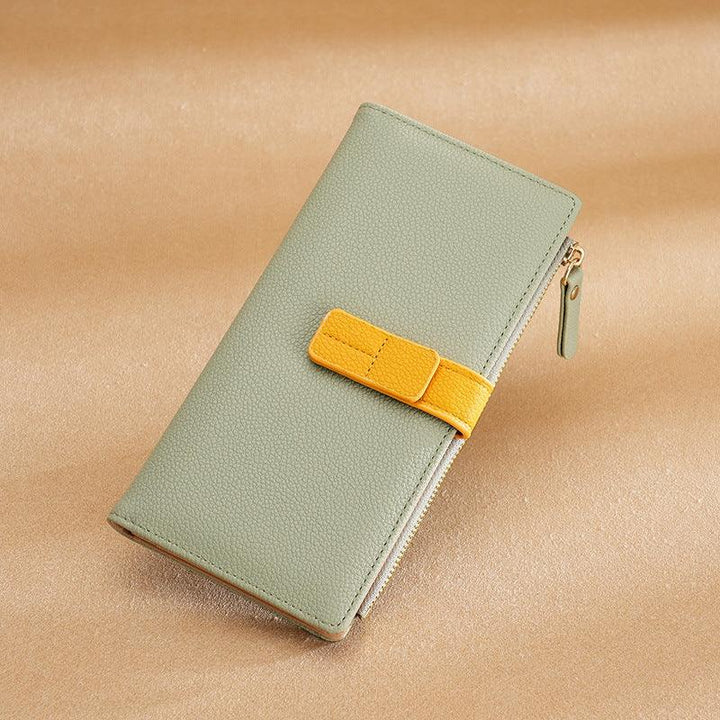 Light green leather wallet with yellow strap and zipper on beige background