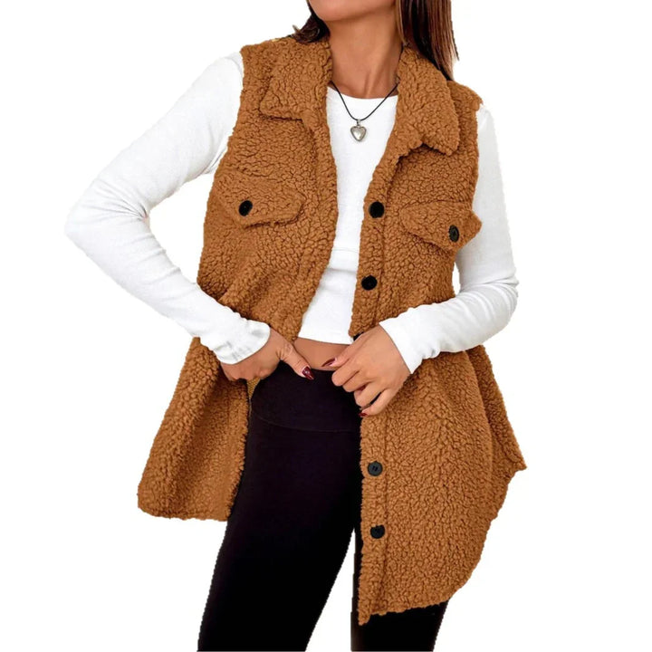 Woman wearing a brown sherpa fleece vest with black buttons over a white long-sleeve top and black leggings