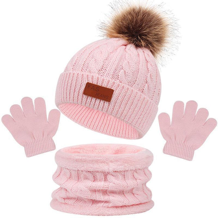 Pink knitted winter hat with brown pom-pom, matching scarf, and gloves set