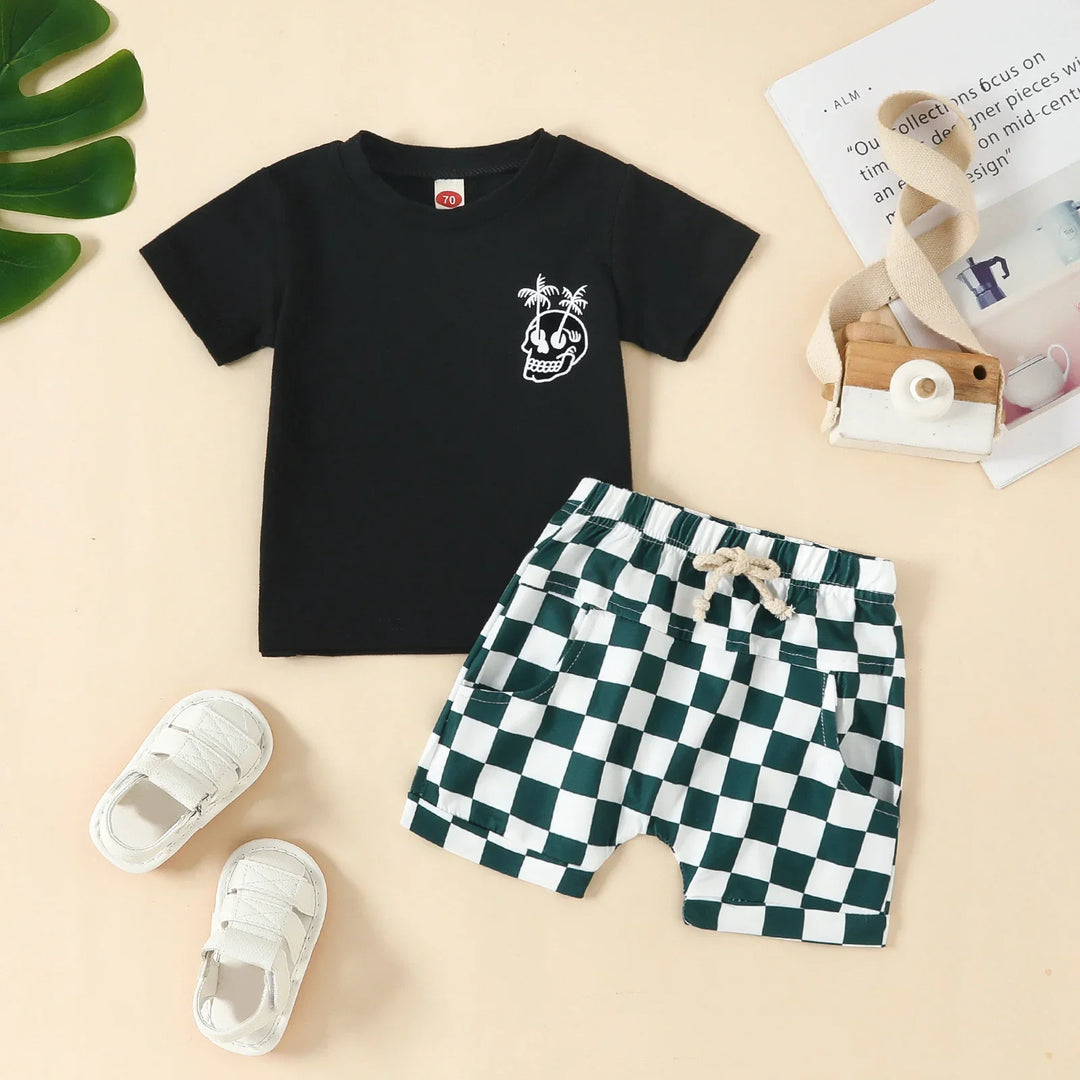 Toddler outfit with black t-shirt featuring skull and palm tree graphic, checkered shorts, and white shoes