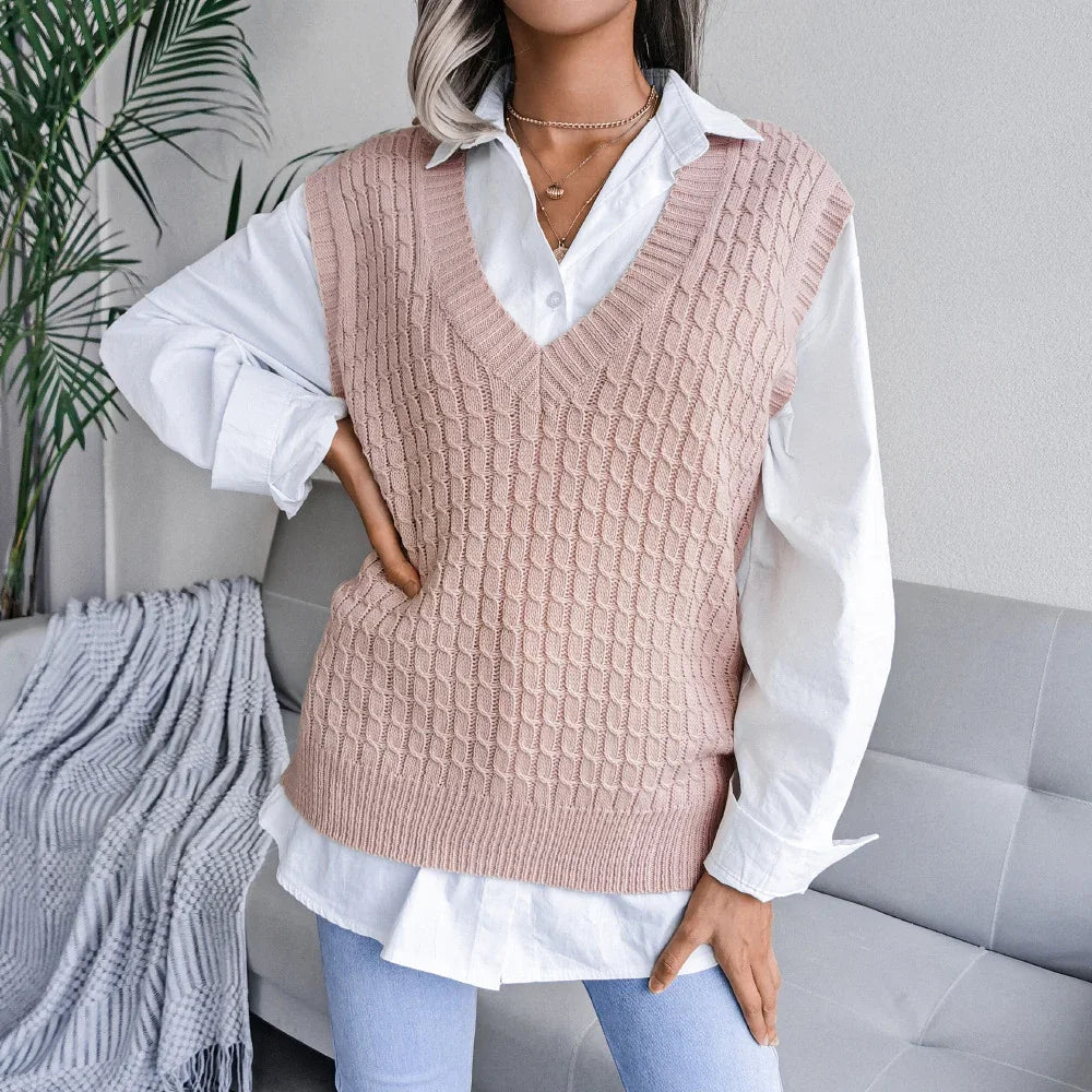 Woman wearing pink cable knit sweater vest over white shirt with blue jeans in modern living room