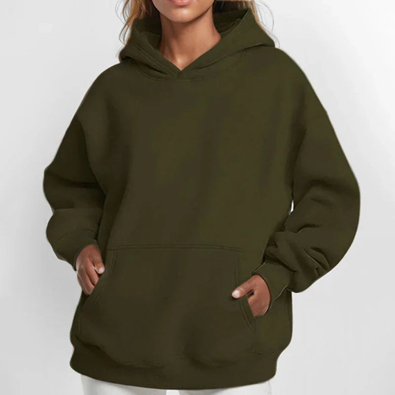 Woman wearing oversized olive green hoodie with kangaroo pocket and hood