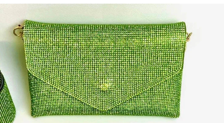 Green rhinestone encrusted clutch bag with gold chain strap on white background