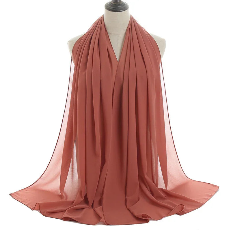 Lightweight rust orange chiffon scarf displayed on a white mannequin bust