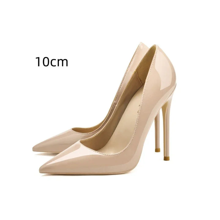 Pair of beige patent leather high heels with 10cm stiletto heels on white background