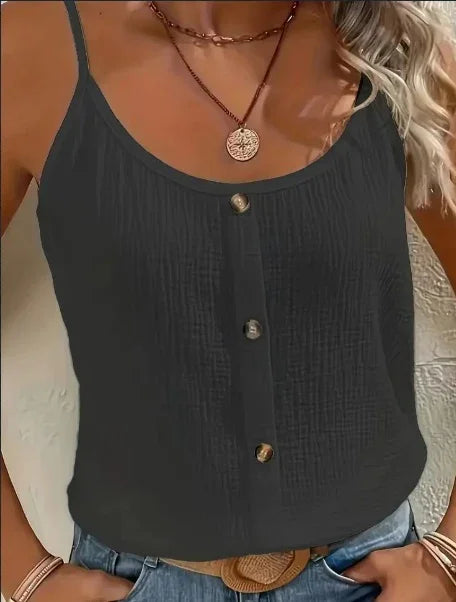 woman wearing black textured sleeveless top with buttons, layered necklaces, and blue jeans