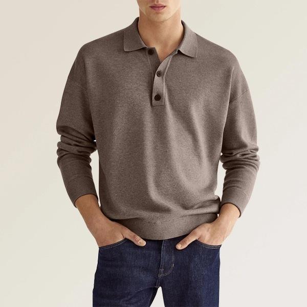 Male model wearing brown long-sleeve polo shirt with dark blue jeans on beige background