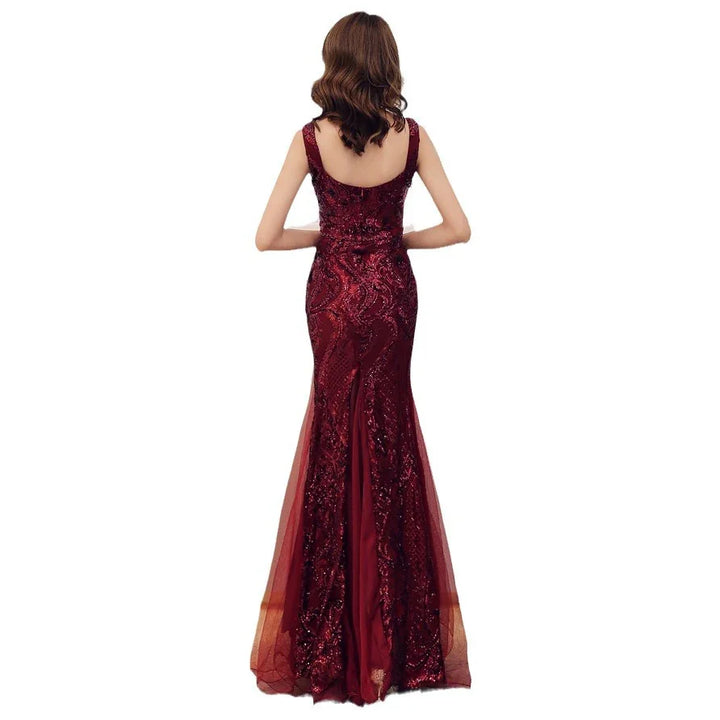 Back view of woman wearing a sleeveless burgundy sequin evening gown with sheer tulle flare