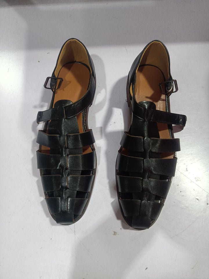 Pair of black leather men’s sandals with buckle straps on white background