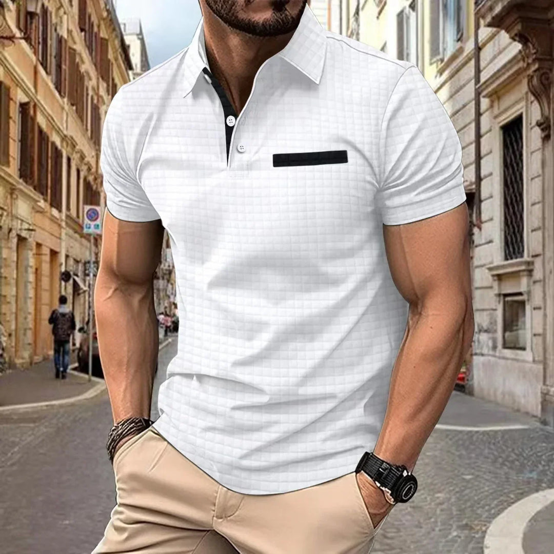 Man wearing white short-sleeve polo shirt with black accent and beige pants in urban street setting