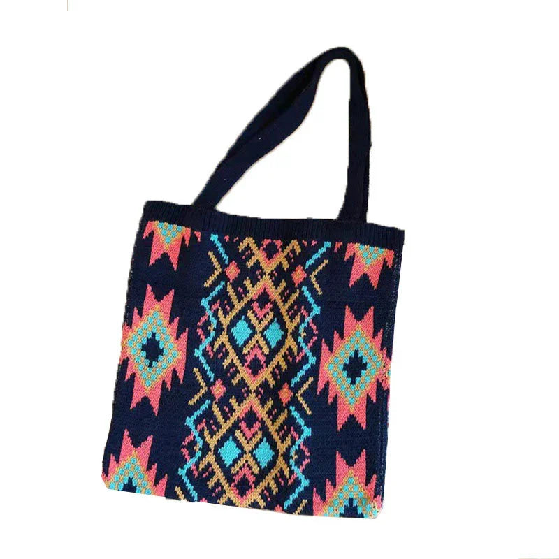 Colorful woven tote bag with geometric tribal patterns in pink, blue, and yellow on navy background