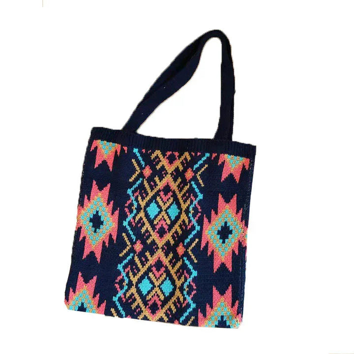Colorful woven tote bag with geometric tribal patterns in pink, blue, and yellow on navy background