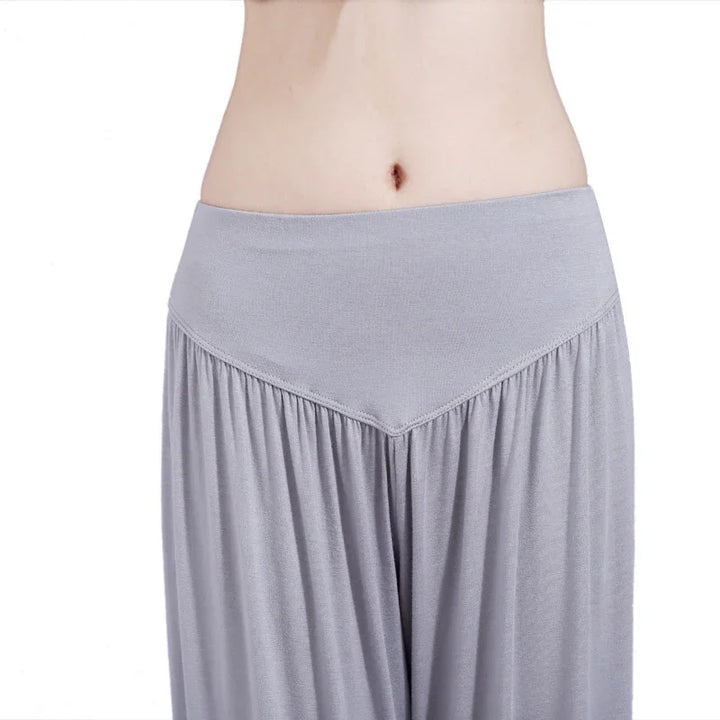 Close-up of woman wearing light gray high-waisted flowy lounge pants with wide waistband