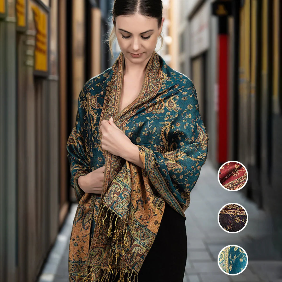 Woman in an alley wearing a teal and gold paisley shawl with fringe, showcasing fabric swatches