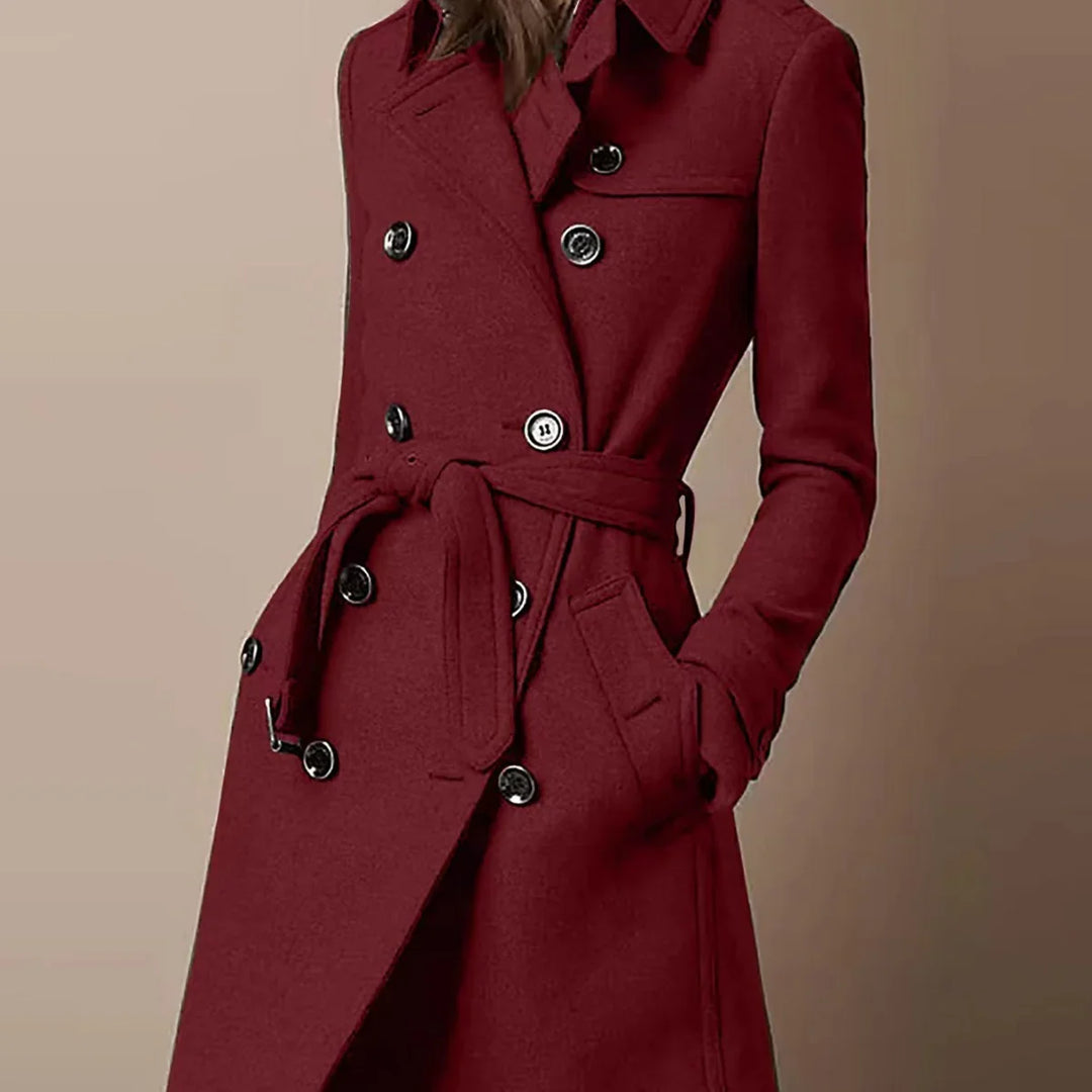 Woman wearing a stylish burgundy double-breasted wool coat with black buttons and waist belt