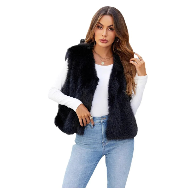Woman wearing black faux fur vest over white long sleeve top with light blue jeans