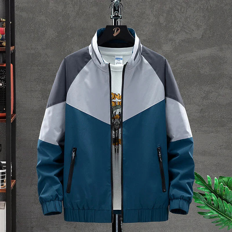 Men's colorblock zip jacket in blue, gray, and white on black hanger against gray wall