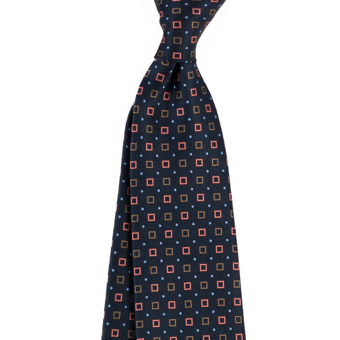 Navy blue men's necktie with red and brown square pattern and small blue dots on white background