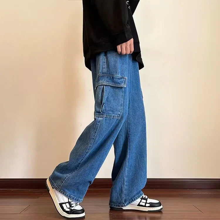 Person wearing loose blue denim cargo pants and black white sneakers on wooden floor