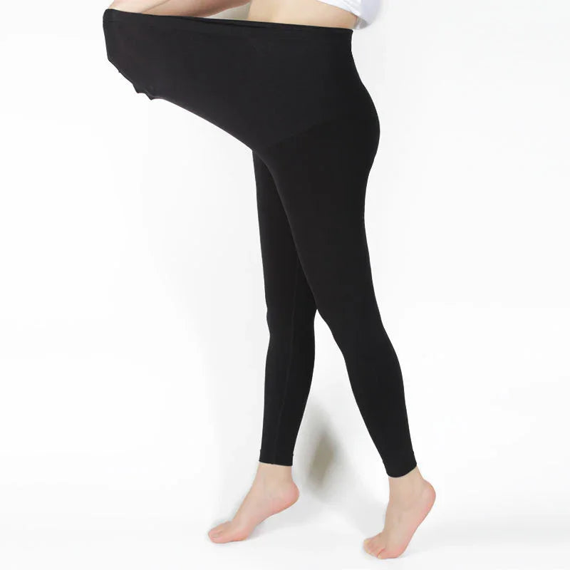 Stretchy black maternity leggings showing elastic waistband extension on white background