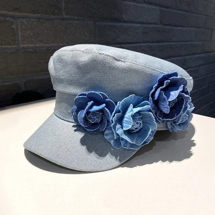 Light blue denim cap with three decorative blue fabric flowers on the side
