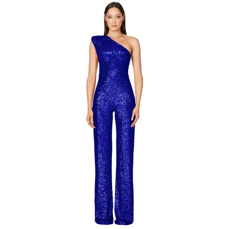 Woman wearing a royal blue one-shoulder sequin jumpsuit with wide-leg pants on white background