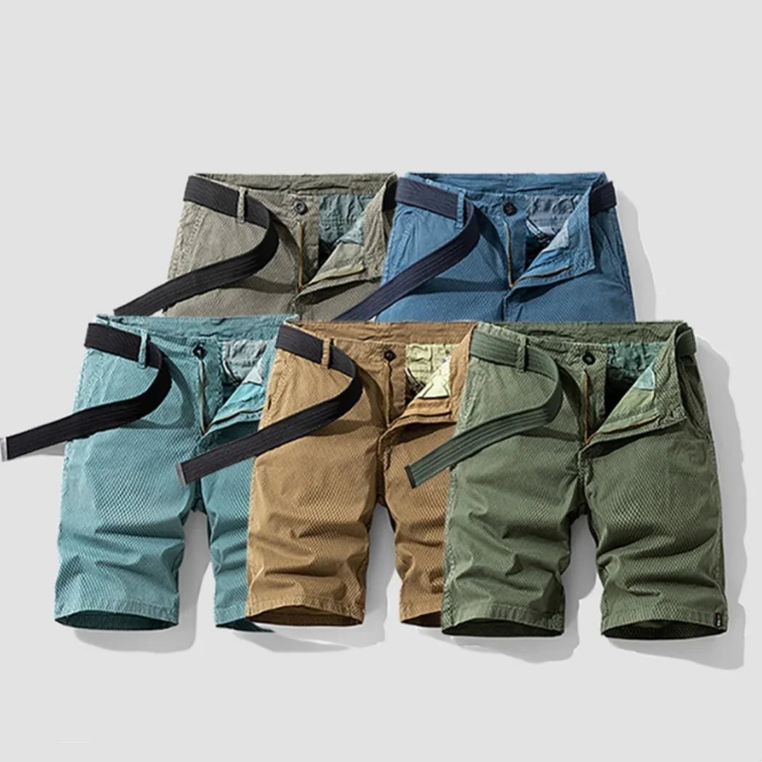 Five pairs of men's casual shorts in blue, khaki, green, gray, and turquoise with black belts laid out on white background