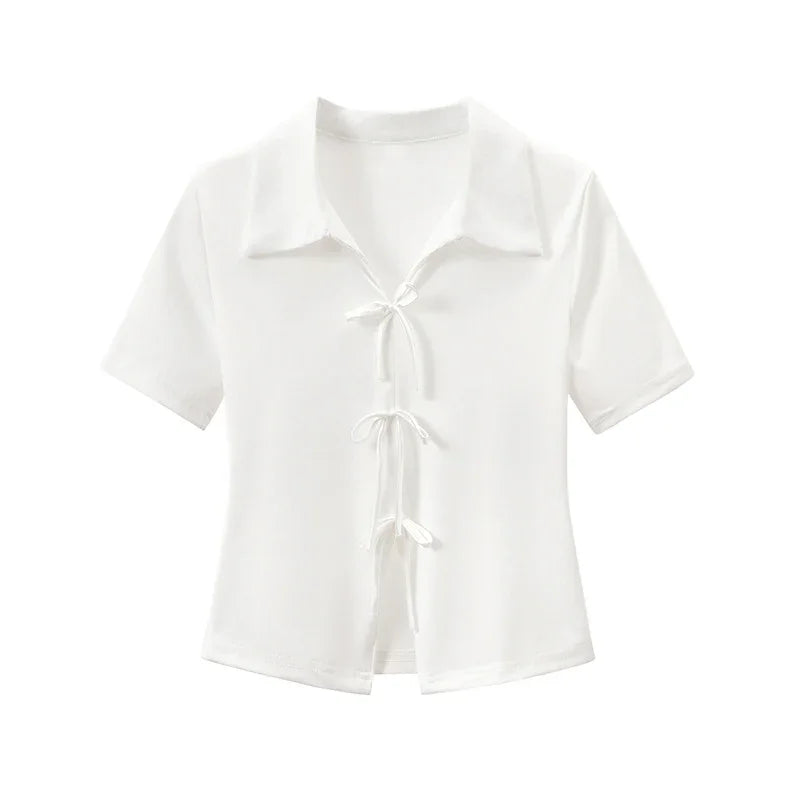 White short sleeve blouse with collar and three front tie closures on plain background