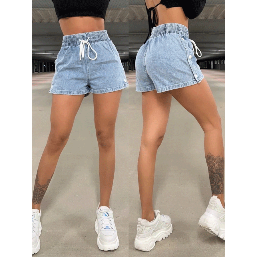 Woman modeling light blue denim shorts with elastic waist and white drawstring in indoor parking