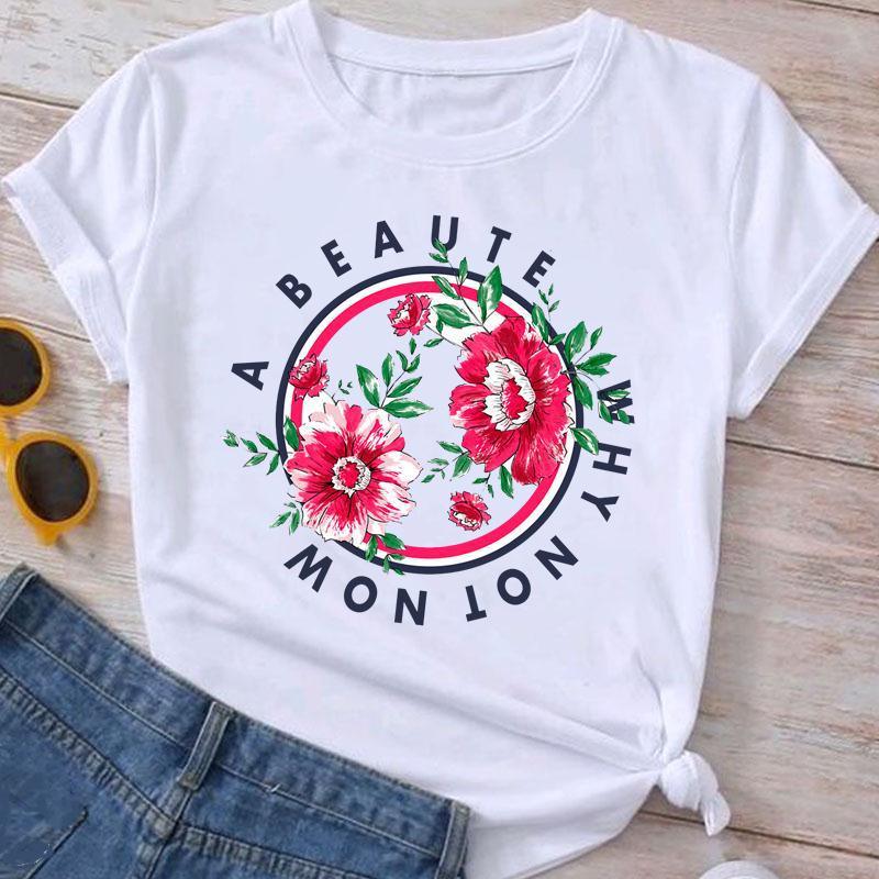 White t-shirt with floral design and text 'A BEAUTY WHY NOT NOW' paired with denim shorts and yellow sunglasses