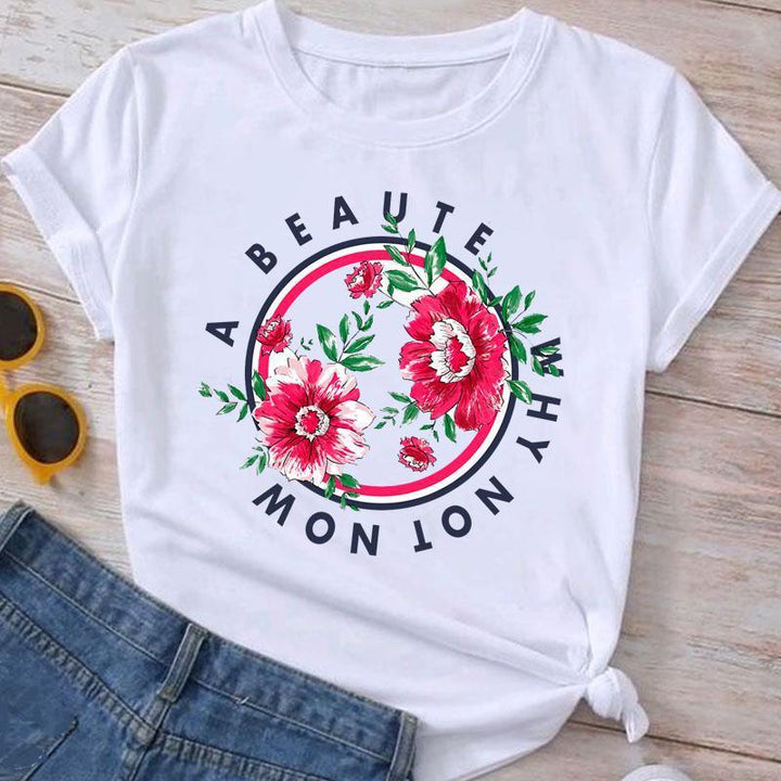 White T-shirt with red floral design and circular text reading 'A BEAUTY WHY NOT NOW', styled with jeans and sunglasses