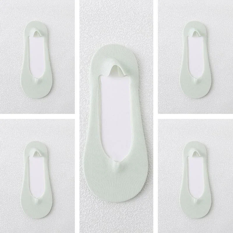 Light green no-show liner socks displayed on a white textured background