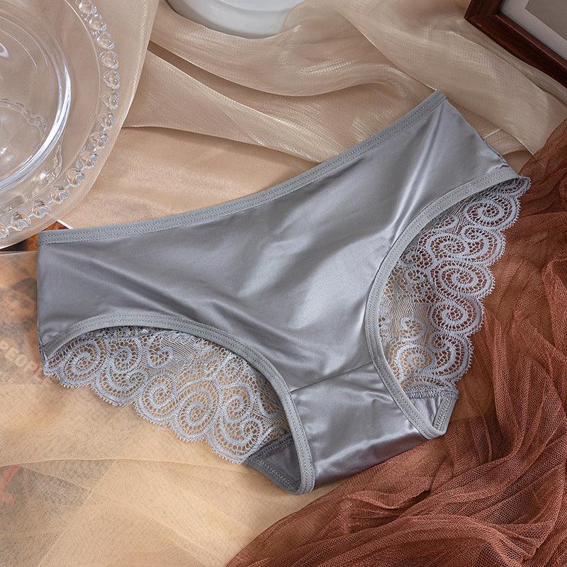 Gray women's lace-trimmed satin panties on beige and brown fabric background