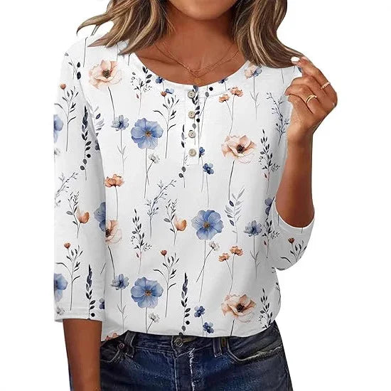 woman wearing white long sleeve floral blouse with blue and peach flowers, paired with dark jeans